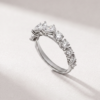 Angled view of a K18 white gold ring with pear-shaped and round diamonds