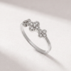 Angled view of a K14 white gold ring with three diamond-set flower motifs