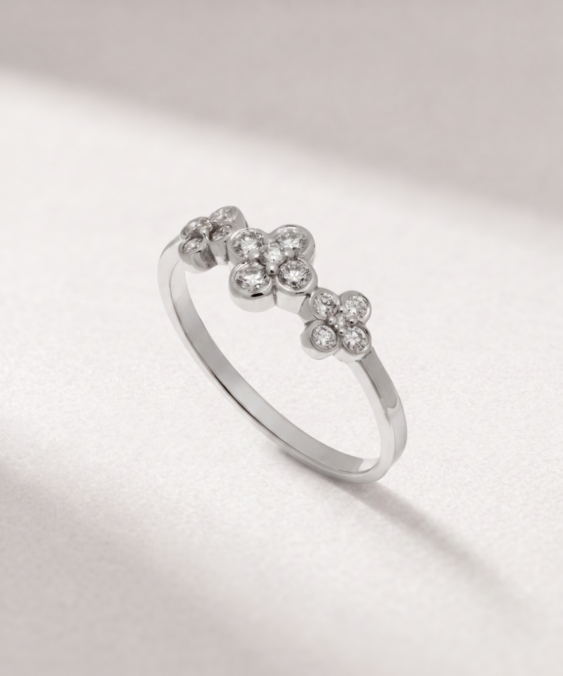 Angled view of a K14 white gold ring with three diamond-set flower motifs