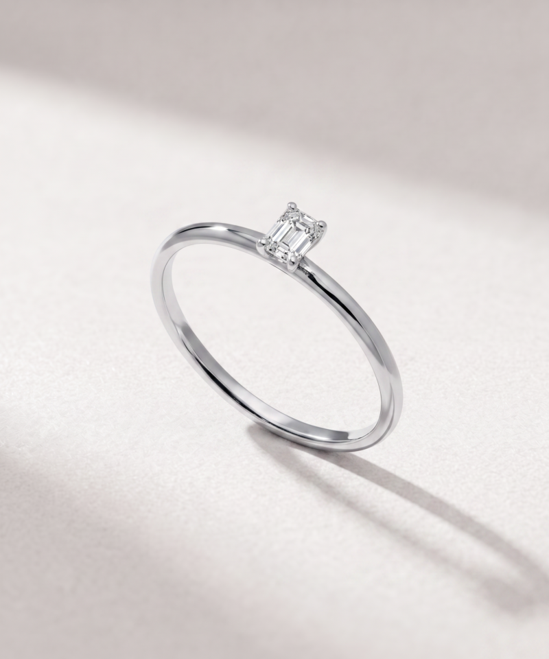 Angled view of an emerald-cut diamond solitaire ring in K14 white gold