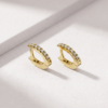 Diamond huggie earrings in K18 yellow gold shown from an angled view