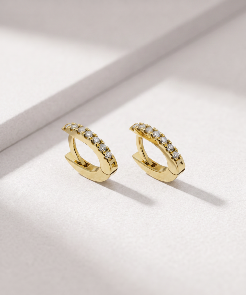 Diamond huggie earrings in K18 yellow gold shown from an angled view