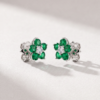 Emerald and diamond flower earrings in K18 white gold shown in a close-up lifestyle image