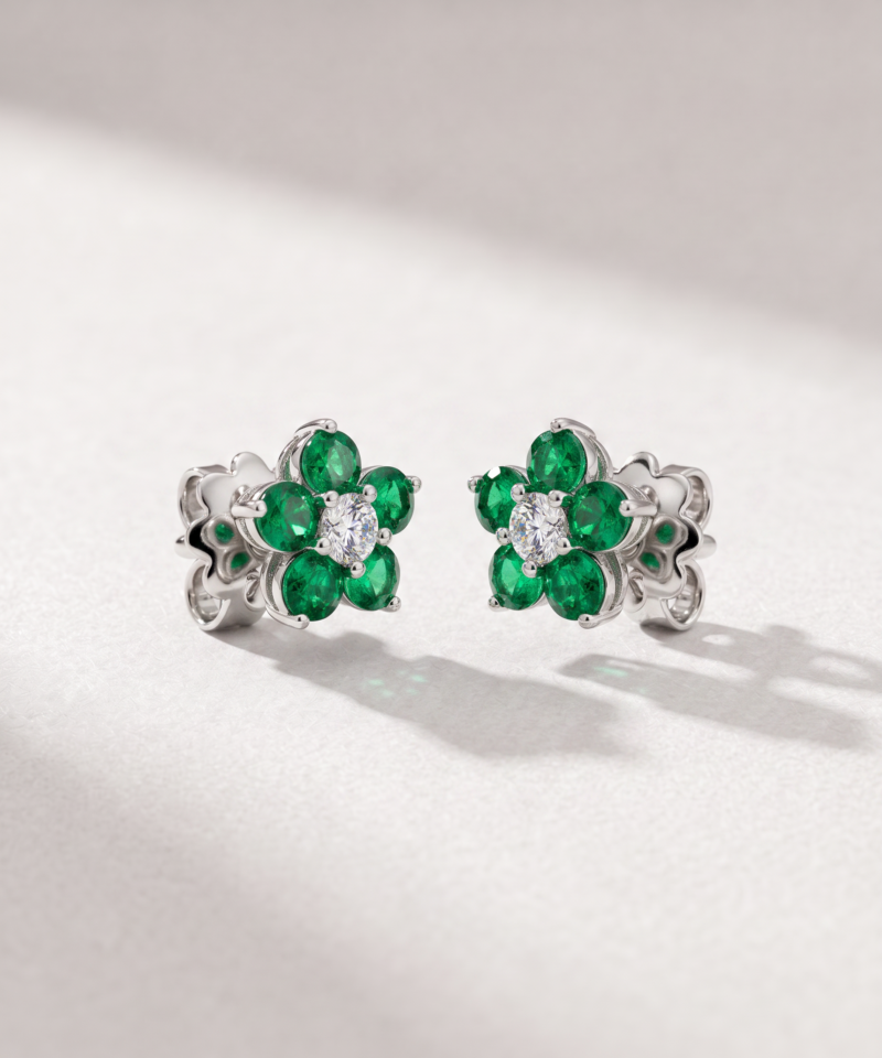 Emerald and diamond flower earrings in K18 white gold shown in a close-up lifestyle image