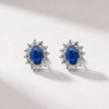 Oval sapphire and diamond halo earrings in K18 white gold shown from the front
