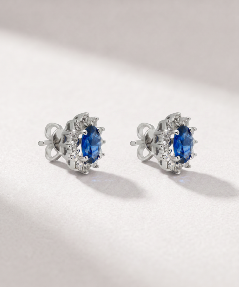 Side view of K18 white gold sapphire and diamond halo earrings with butterfly backs