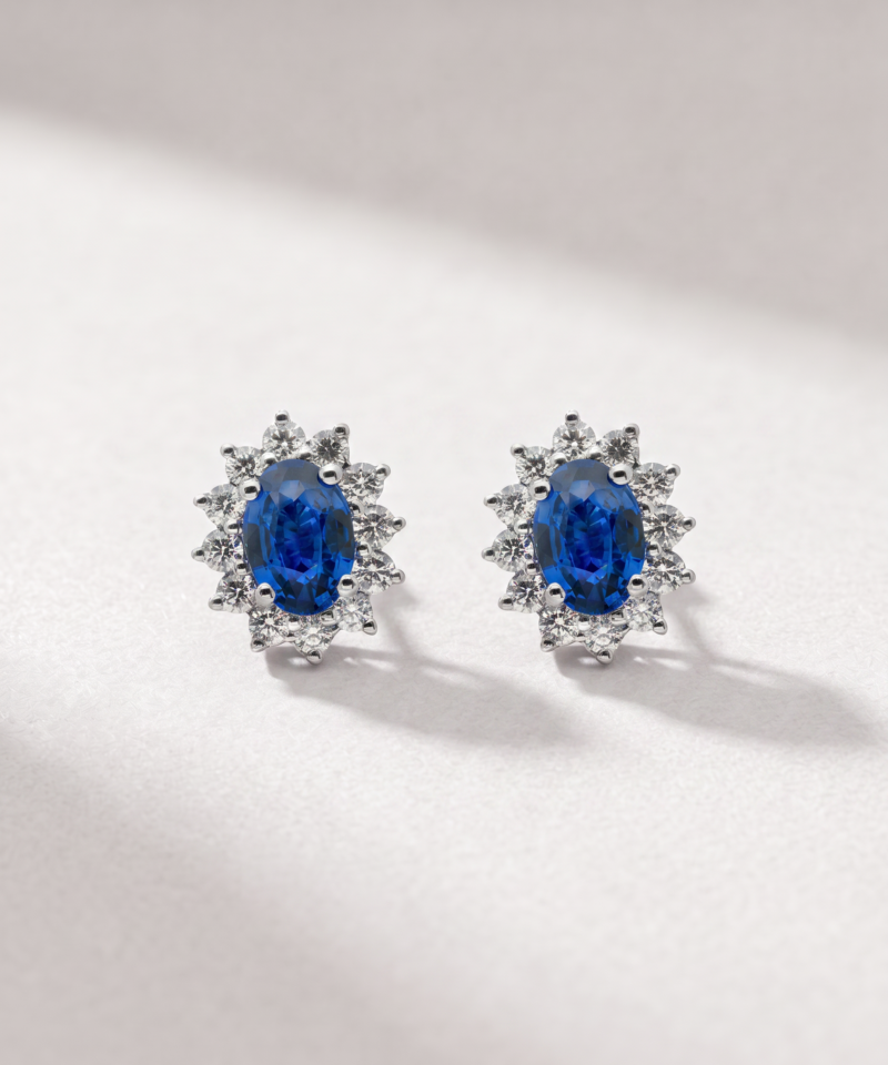 Oval sapphire and diamond halo earrings in K18 white gold shown from the front