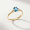 Oval-cut blue topaz cluster ring in K14 yellow gold