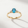 Oval-cut blue topaz cluster ring in K14 yellow gold