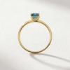 Emerald-cut blue topaz ring in K14 yellow gold with stone-set shoulders