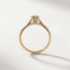 Profile view of a K18 yellow gold green diamond ring showing the hidden diamond halo